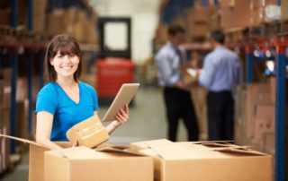 Woman scanning box in warehouse with mobile tablet